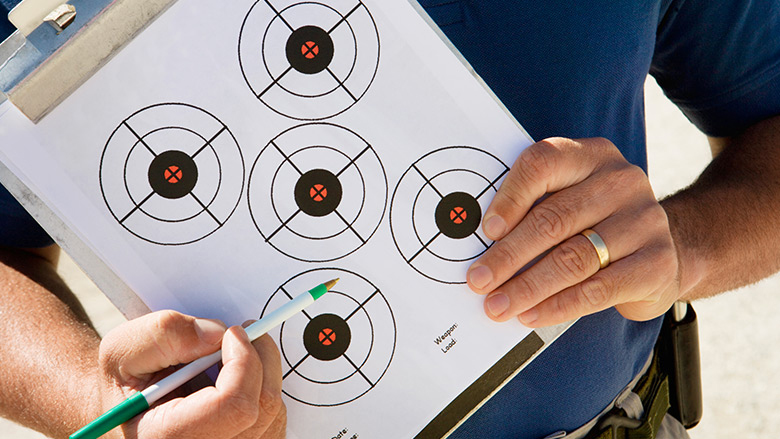 NRA Instructor Pointing to a Target on his Clipboard.
